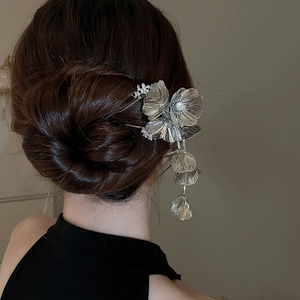 Detailed view of silver flower hair pin with sparkling crystals and long tassel fringe