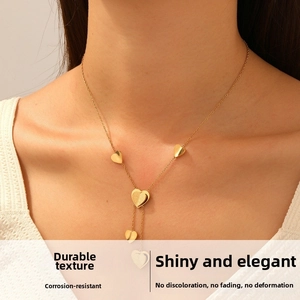 Close-up of gold-plated layered heart pendant necklace worn on a female neck