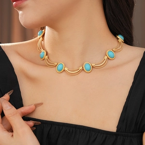 Macro shot of vintage style gold necklace with oval turquoise stones on a model