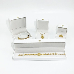Close-up of golden jewelry set with bracelets and necklace in crown-embossed white boxes