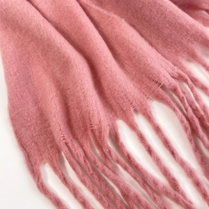 Close-up of soft pink mohair scarf showing fluffy texture and delicate tassel fringe detail