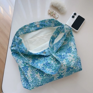Flat lay of floral cotton bag interior with magnetic clasp and small pocket