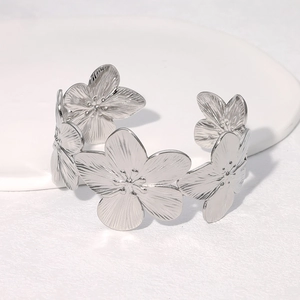 Macro detail of silver floral wide cuff bracelet with intricate metal petal textures