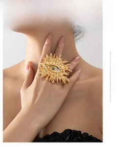 Dettaglio anello vintage dorato a forma di occhio con cristalli e raggi solari