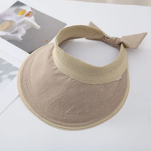 Detail of beige quilted sun visor featuring an elegant bow and breathable woven edge
