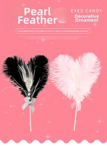 Detail of heart-shaped cake topper with natural ostrich feathers and pearls