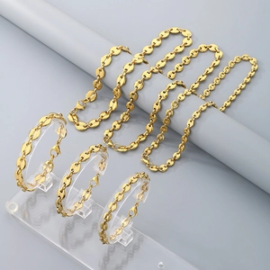 Detail of 18K gold coffee bean link necklace and bracelet sets on acrylic stands