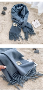 Detail shot of blue scarf showing material label with cotton and polyester blend fabric