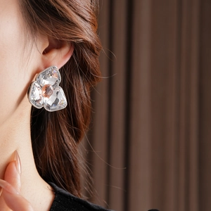 Detail of luxury rhinestone flower stud earrings in pink and clear crystal on a model