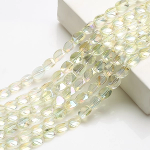 Close-up of faceted 10x12mm pale yellow iridescent crystal beads on white background