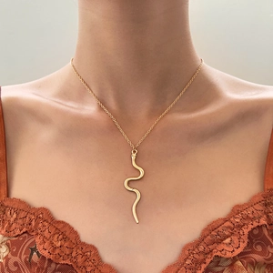 Elegant gold snake pendant necklace for women worn with a chic orange lace outfit