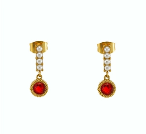 Detail of drop earrings with white pearls and a faceted red gemstone in gold setting