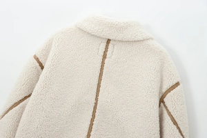 Vue détaillée du col arrière et de la texture polaire d'une veste blanche en peluche