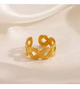 Macro view of gold woven adjustable ring detail on soft white silk background