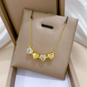Macro di una collana a quadrifoglio dorata con cristalli in un'elegante scatola regalo
