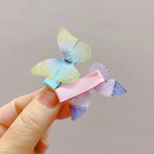 Close-up of butterfly hair clips with rhinestone details and gradient mesh fabric wing