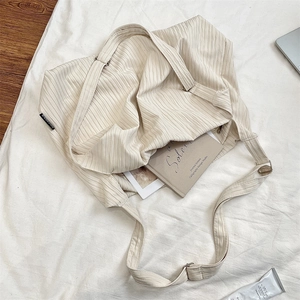 Close-up of off-white large canvas tote bag with striped texture and adjustable strap