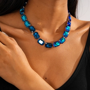 Detailed view of necklace with royal blue rectangular gems on a silver setting