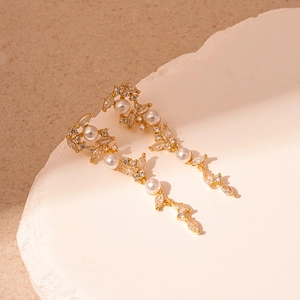 Detail of elegant gold tassel earrings with marquise zircons and white pearls