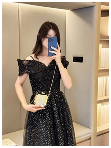Detail of a sparkling black sequin dress paired with a gold hexagonal metal clutch bag