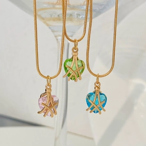 Vista detallada de colgantes de corazón rosa, verde y azul en cadenas doradas