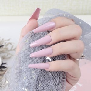 Close-up of extra-long nude pink coffin nails with high-gloss UV finish on hand
