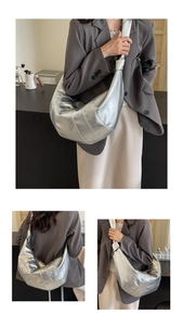 Detail of silver metallic croissant bag showing knotted strap and quilted texture