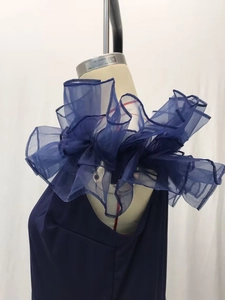 Detailansicht des dunkelblauen Abendkleids mit mehrlagigen Organza-Rüschen an der Schulter