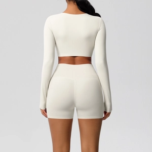 Detail van een crème yoga-set met top met lange mouwen en strakke sportshort