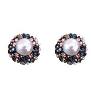 Vintage round pearl earrings with multicolored crystals and small white gems in studio light