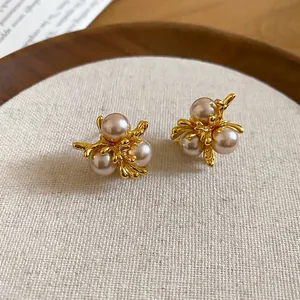 French vintage champagne pearl earrings with gold floral base shown from a 45-degree angle