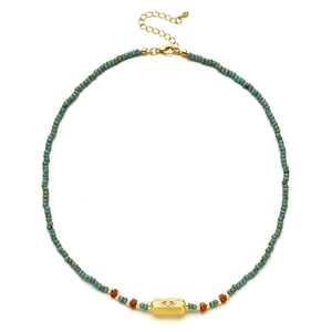 Detail of turquoise beaded necklace with gold Evil Eye pendant and adjustable chain