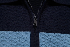 Macro detail of men's polo shirt featuring blue wavy knit texture and premium metal zipper