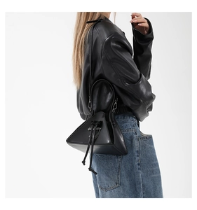 Model wearing a black punk triangle crossbody bag with silver chains and PU leather texture