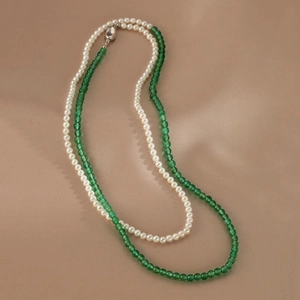 Close-up of double-layer necklace with white pearls and green agate beads on silk