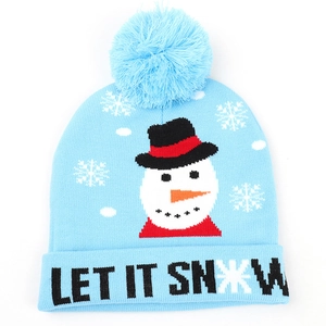 Detail of light blue knit hat featuring plush pom-pom and LET IT SNOW snowman pattern