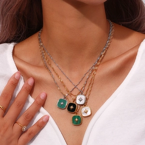Layered stainless steel necklaces with gold starburst shell square pendants on model