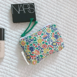 Detailed close-up of floral cotton pouch with colorful pattern and zipper puller