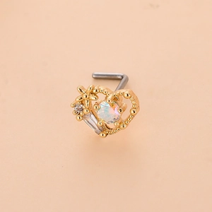 Vista macro del piercing naso a L in oro con design a cuore e pietra opale