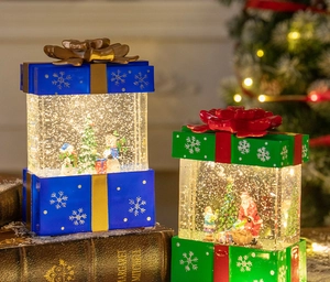 Close-up of lighted Christmas gift box lanterns with snowmen and glitter in warm holiday scene
