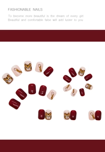 Close-up of cute tiger cartoon nail art stickers and glossy red press-on false nails