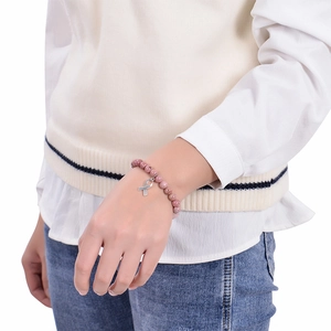Bracelet en perles de cristal rose avec pendentif ruban argenté porté par un mannequin