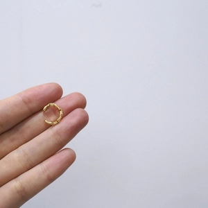 Elegant gold-plated C-shaped ear cuff with diamond accents shown on fingers