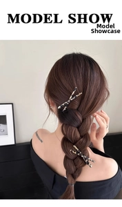 Detail of tortoise shell X-shaped hair clips used as decorative accents on a braided hairstyle