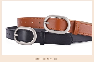 Close-up of slim leather belts with silver oval buckles in black and tan colors