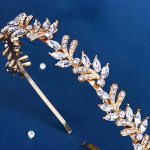 Close-up of golden leaf headband with sparkling rhinestones on deep blue background