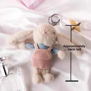 Detail of cute beige plush rabbit wearing pink overalls and blue shirt, height 16cm