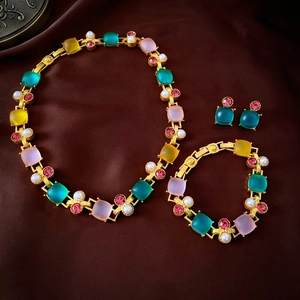 Vintage style jewelry set with colorful gems, pearls and gold chains on brown velvet