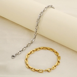 Detailansicht der gold- und silberfarbenen Schweinenasen-Armbänder auf Seide
