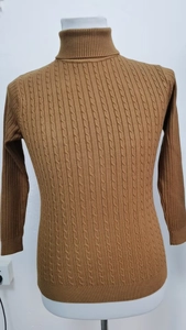 Dettaglio di un maglione marrone a collo alto con classica trama a trecce e colletto